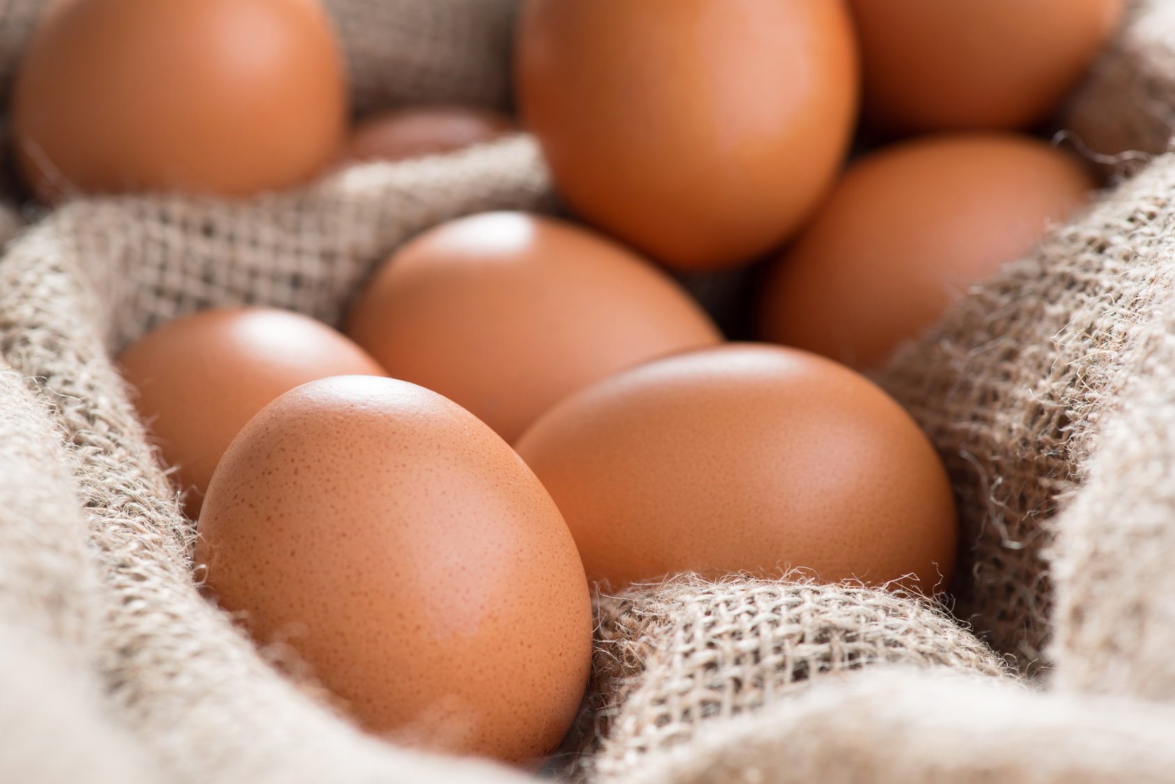 Domestic charm. Close up of fresh chicken eggs lying on the sackcloth