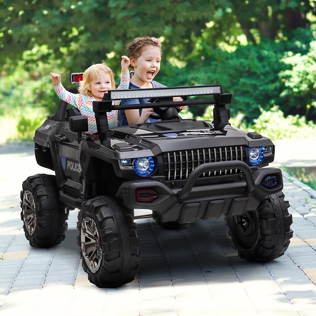 Two children excitedly riding black police toy jeep outdoors.
